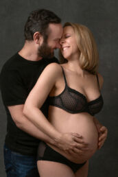 A couples maternity photography studio photoshoot kissing and cuddling