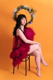 A female London studio photoshoot with flowers and tulle on an orange background