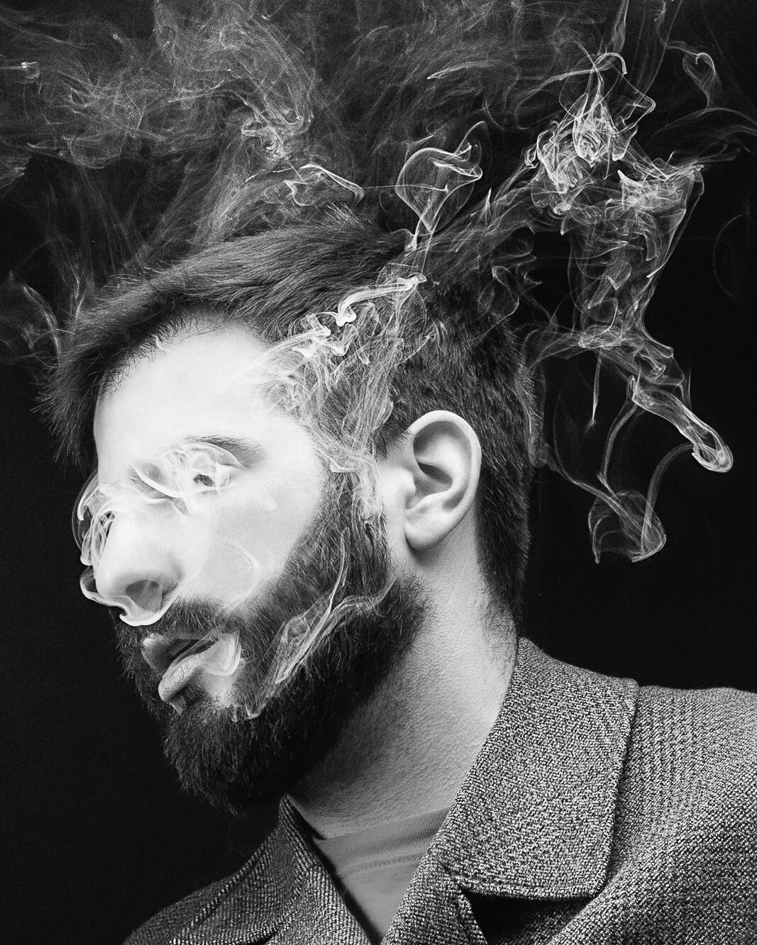 A male London portrait photograph of a man with smoke in his face