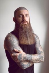 A bearded man with tattoos at a photography studio in London