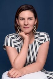 A woman's headshot photograph in London with a stripped dress and big earrings