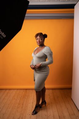 A black woman against an orange backdrop at a London portrait photoshoot
