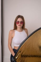 A woman in pink sunglasses in a studio for a London portrait photographer