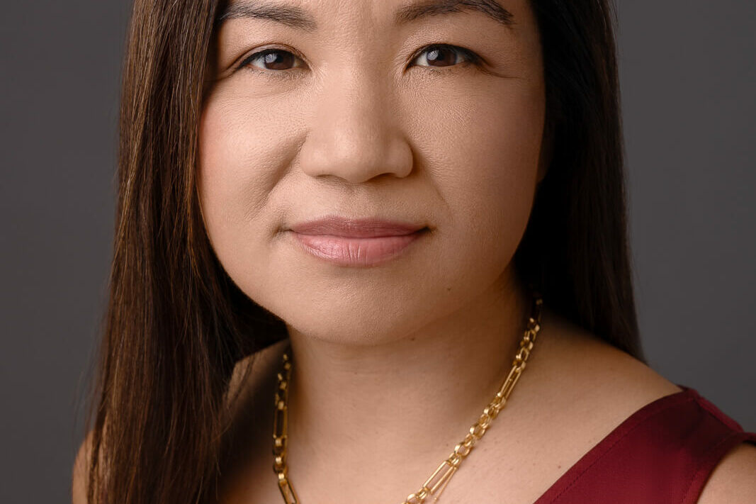 LinkedIn headshot in London of a woman in a red silk vest and gold jewellery