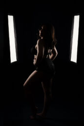 a woman in lingerie surrounded by studio lights on a london portrait photograph