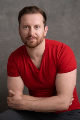 a man wearing a red t-shirt and folded arms on a london headhsot photography photoshoot