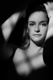 a woman in window light with the idea to love your body with a black and white boudoir photoshoot