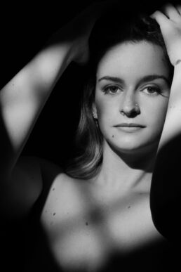 a woman in window light in a tasteful nude photo