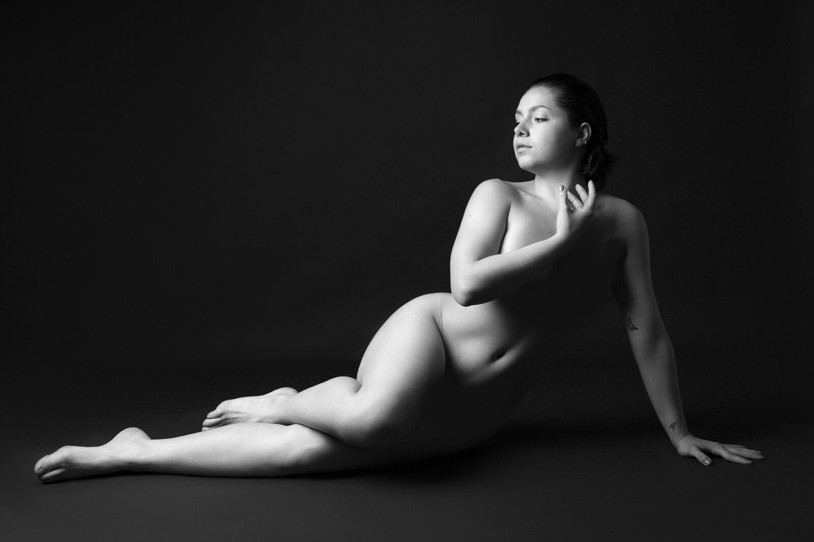 Artistic nude photograph in soft light, showing the human form with elegance and shadow play