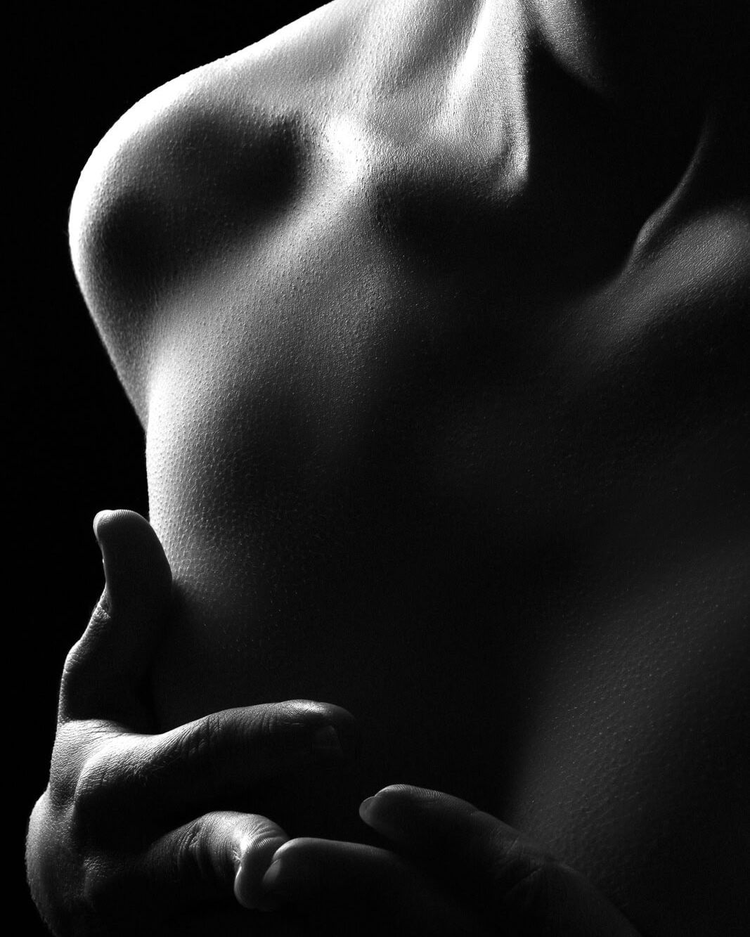 a dark and sultry close up image using silhouette to obscure a tasteful nude photo.
