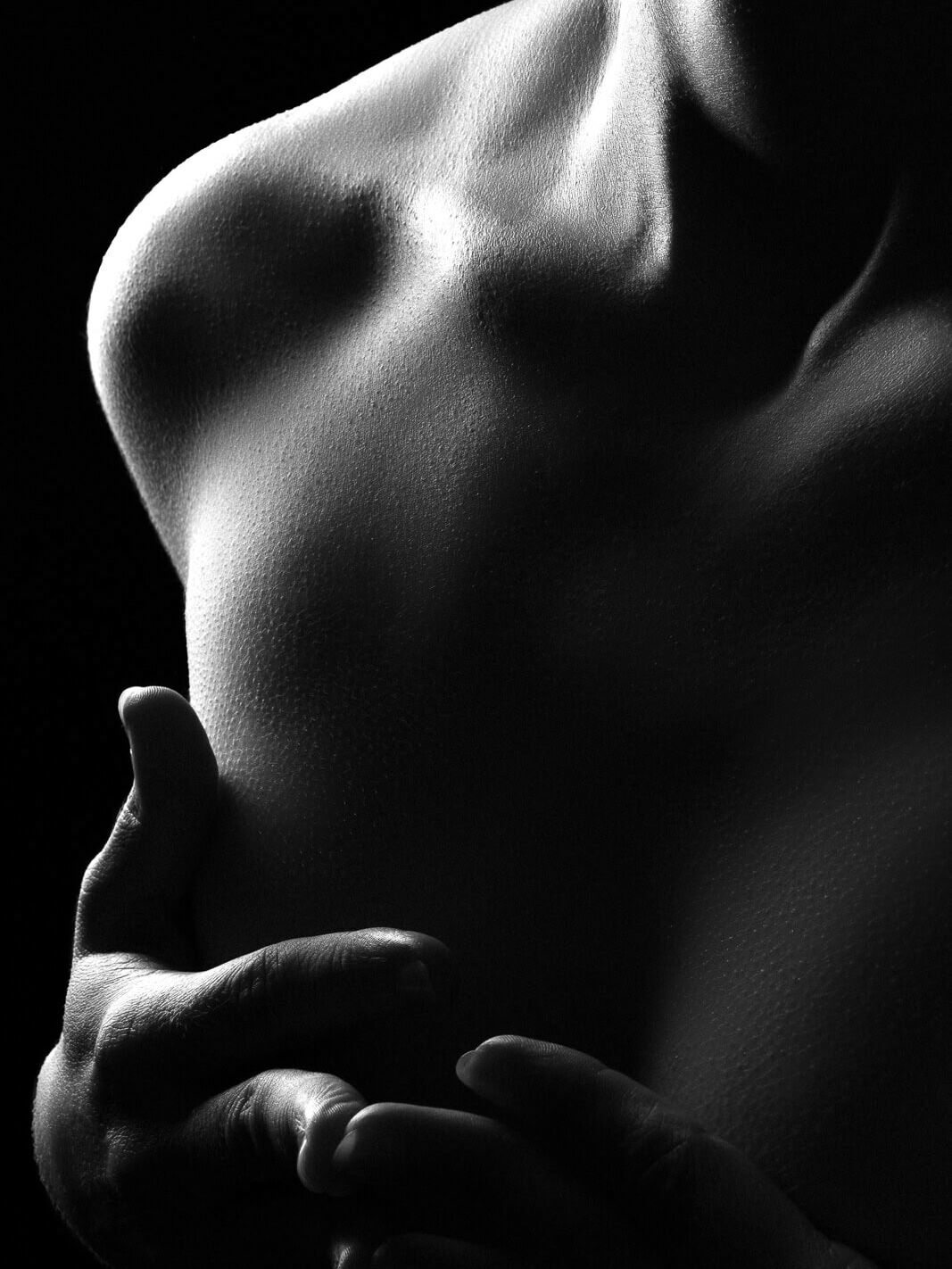 a dark and sultry close up image using silhouette to obscure a tasteful nude photo.