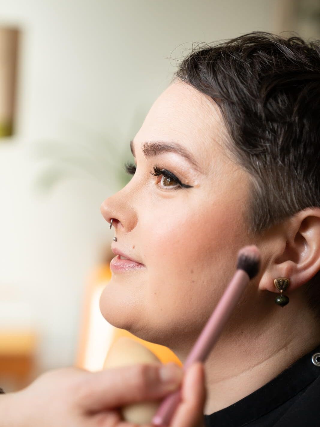 A woman having her boudoir make up looks done on a boudoir photoshoot