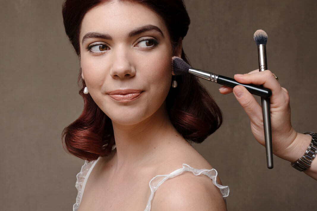 A woman in white lingerie with red hair showing boudoir makeup looks on a London boudoir photoshoot