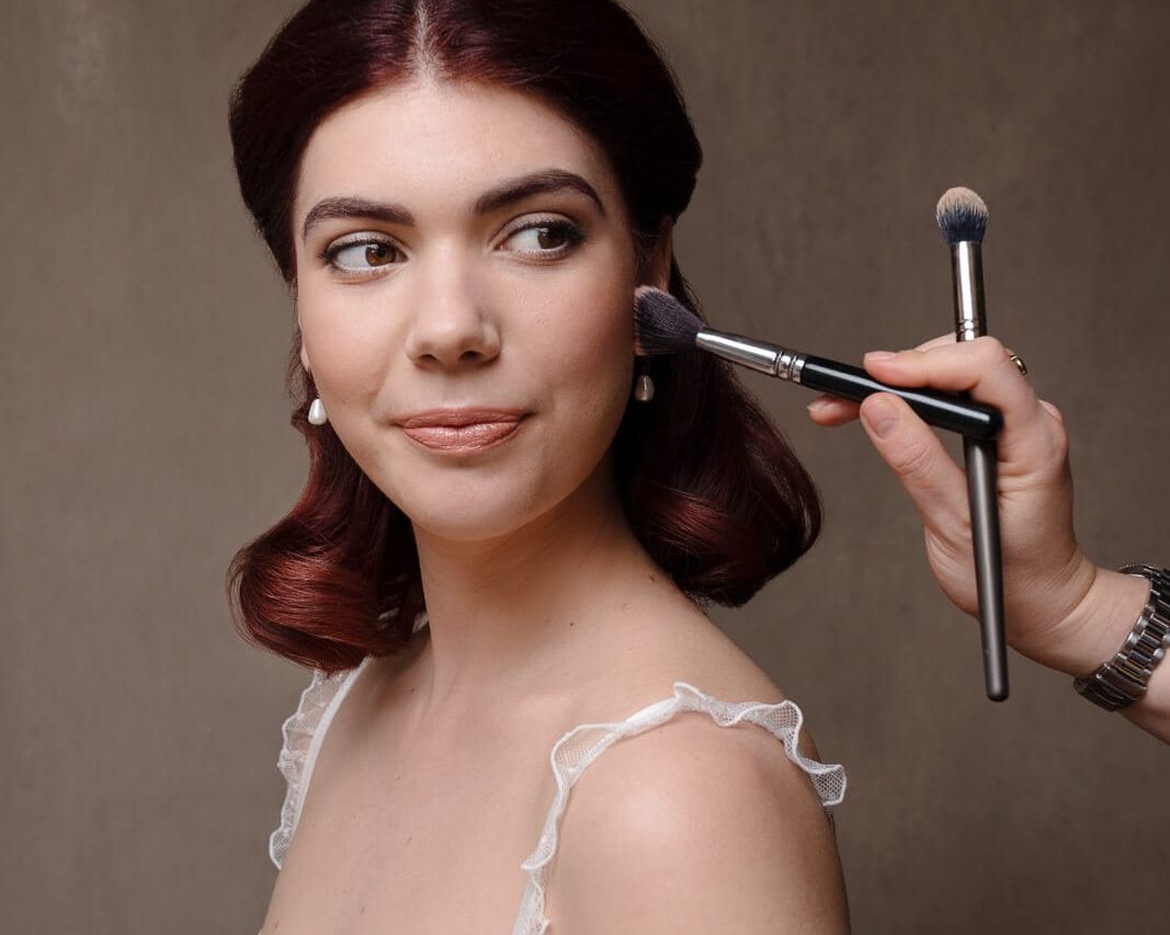 A woman in white lingerie with red hair showing boudoir makeup looks on a London boudoir photoshoot