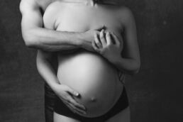 a couples London maternity photoshoot with man covering woman's breasts