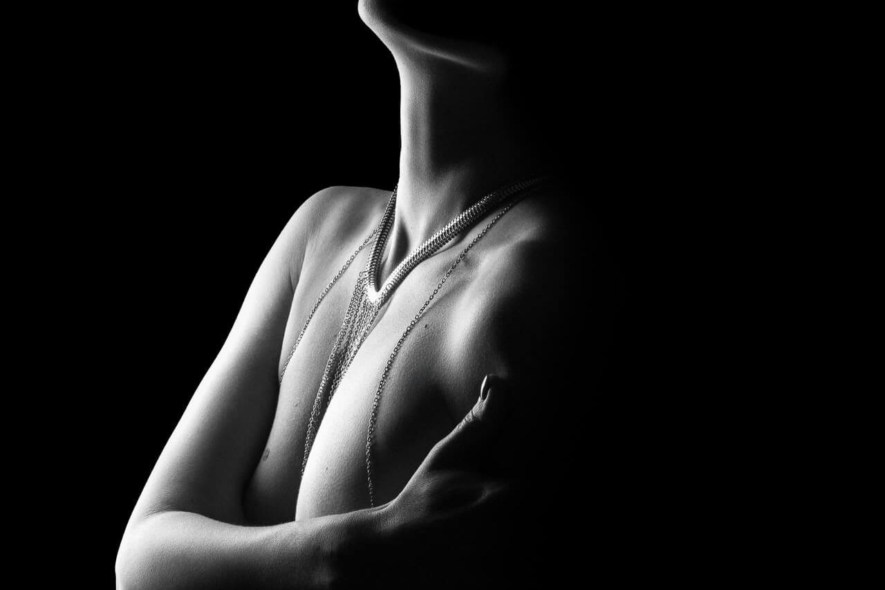 a woman in light silhouette and body chain showing how much is a boudoir photoshoot