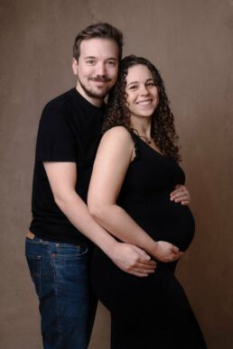 a couple wearing black t shirts and holding each other on a London maternity photography photoshoot