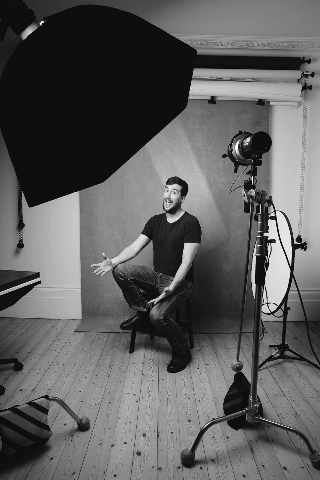 Behind the scenes of a headshot photoshoot with a man smiling and enjoying the session in the studio.