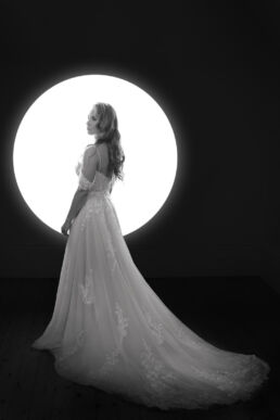 a woman in a wedding dress infront of the moon on a bridal boudoir photography photoshoot in London