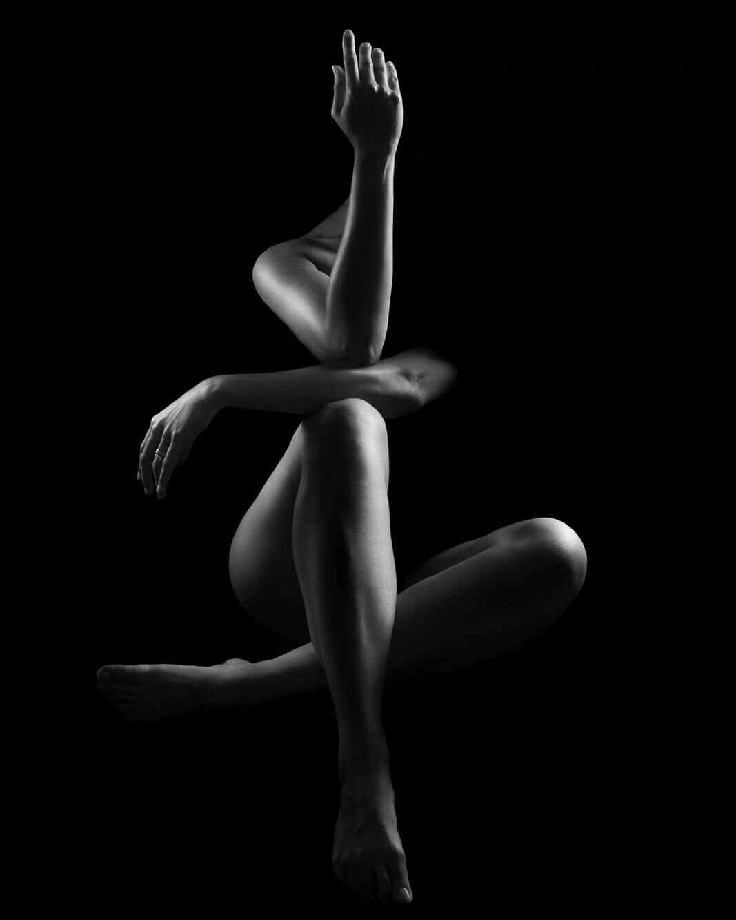 a body outlined in light sitting down at an angle in a boudoir photography photoshoot