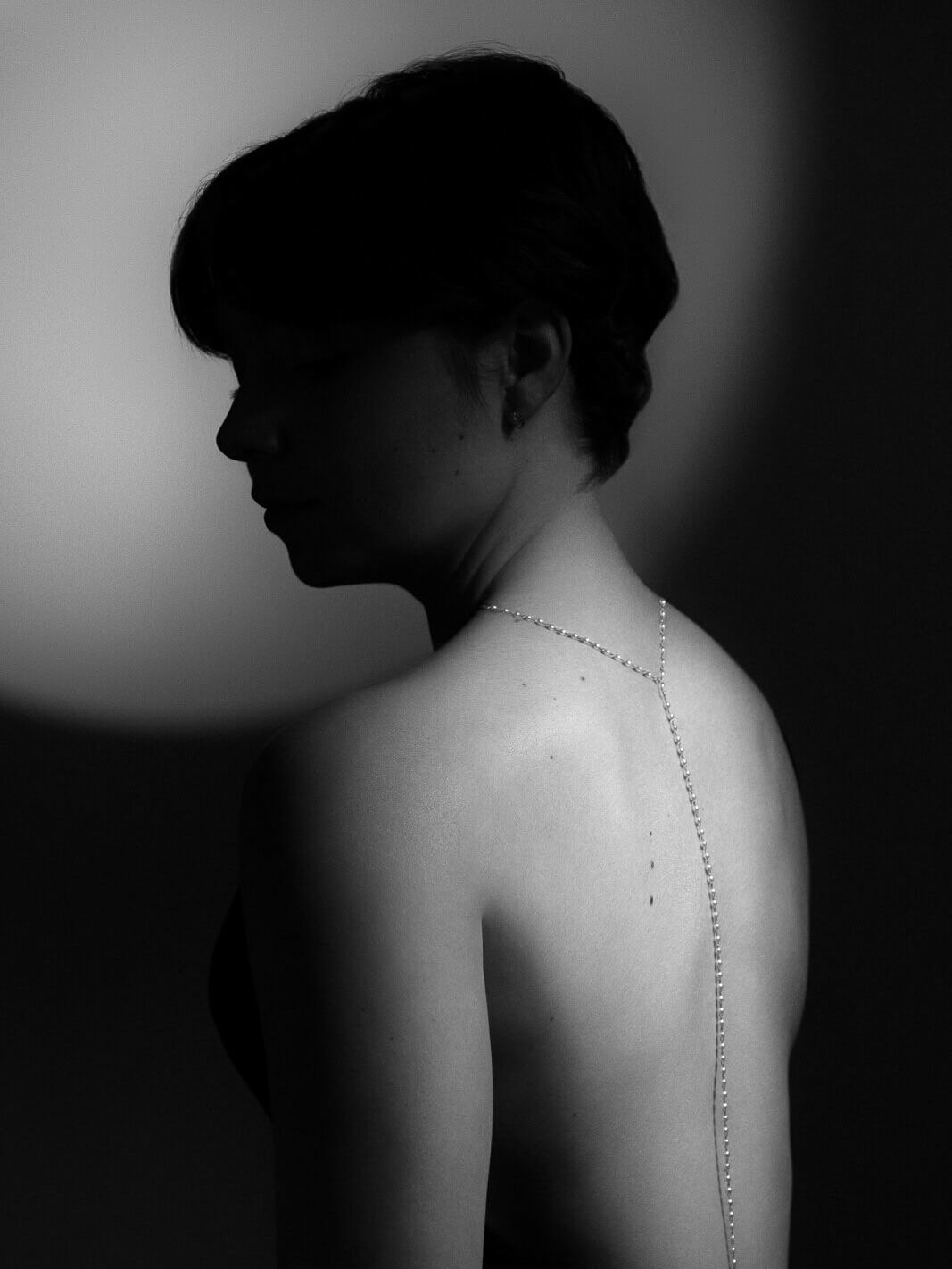 a woman with a pearl necklace down her back with old hollywood lighting designed from a collection of boudoir shots