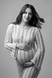 a woman in a woven dress with hair blowing on a london maternity photography photoshoot