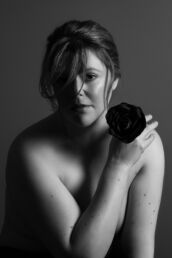 a female boudoir photographer holding a black rose on a london boudoir photography photoshoot
