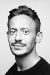 a man in a black t shirt with beard in black and white for a London headshot
