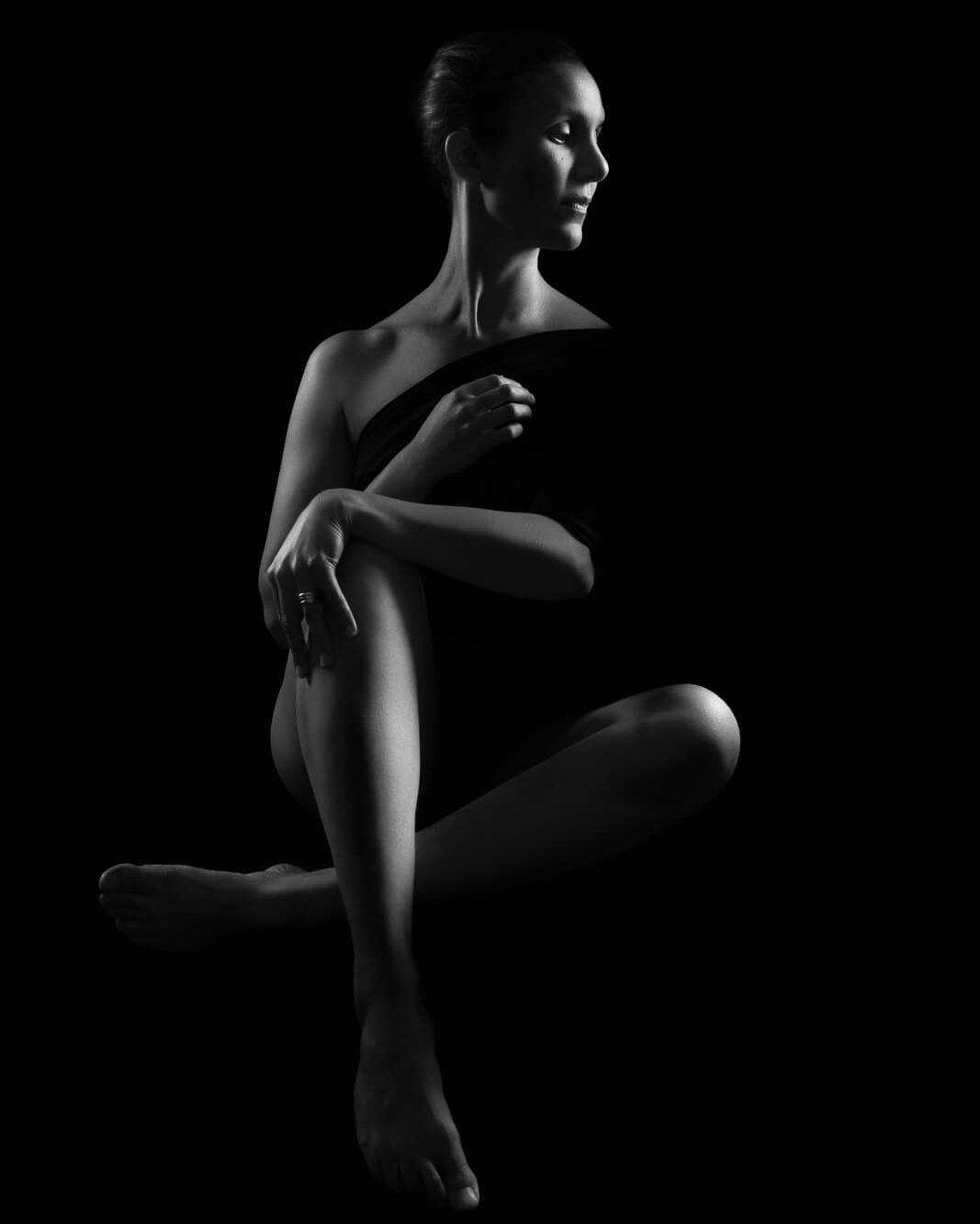 a south asian woman seated holding her knee on a boudoir photoshoot for mums uk