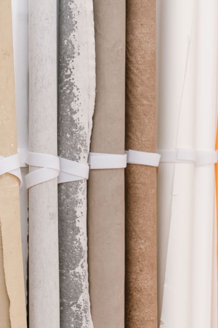 A line of canvas and paper backdrops beside a wooden door inside my London boudoir studio.