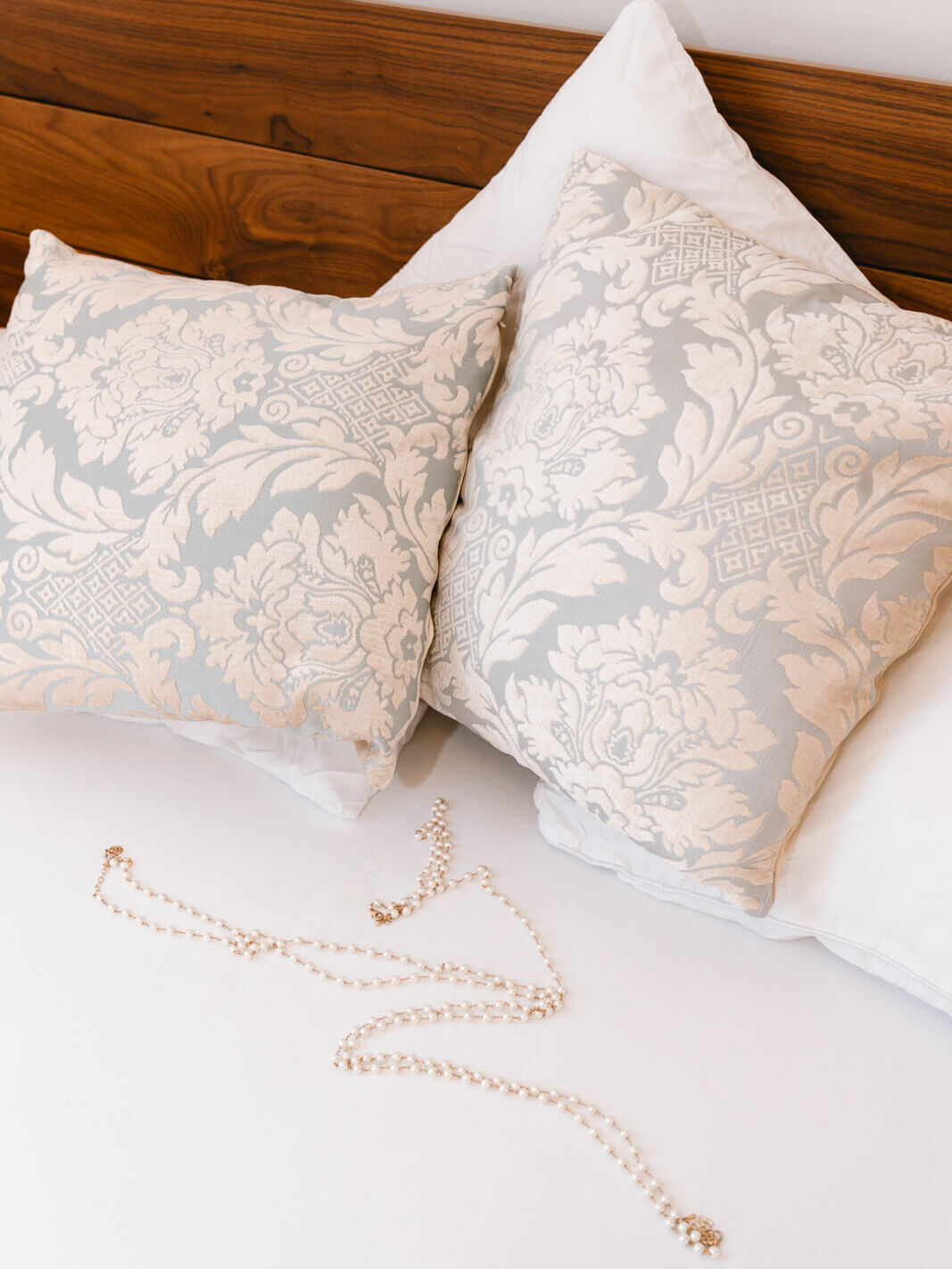 Boudoir bed styled with soft pillows and pearls inside my London boudoir studio, a romantic, intimate setting for your photoshoot