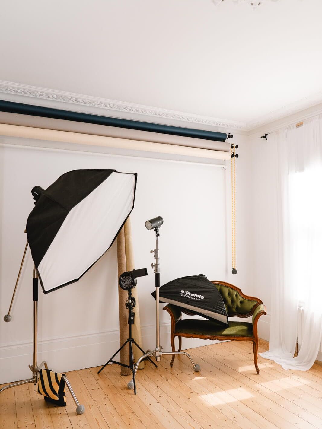 Wooden floors, natural light, and professional studio equipment set up near a window inside my London boudoir studio