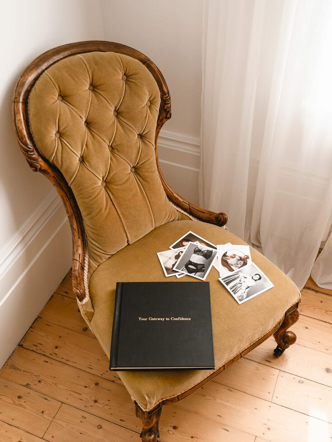 Boudoir albums and prints displayed on a chair by the window, keepsakes from inside my London boudoir studio
