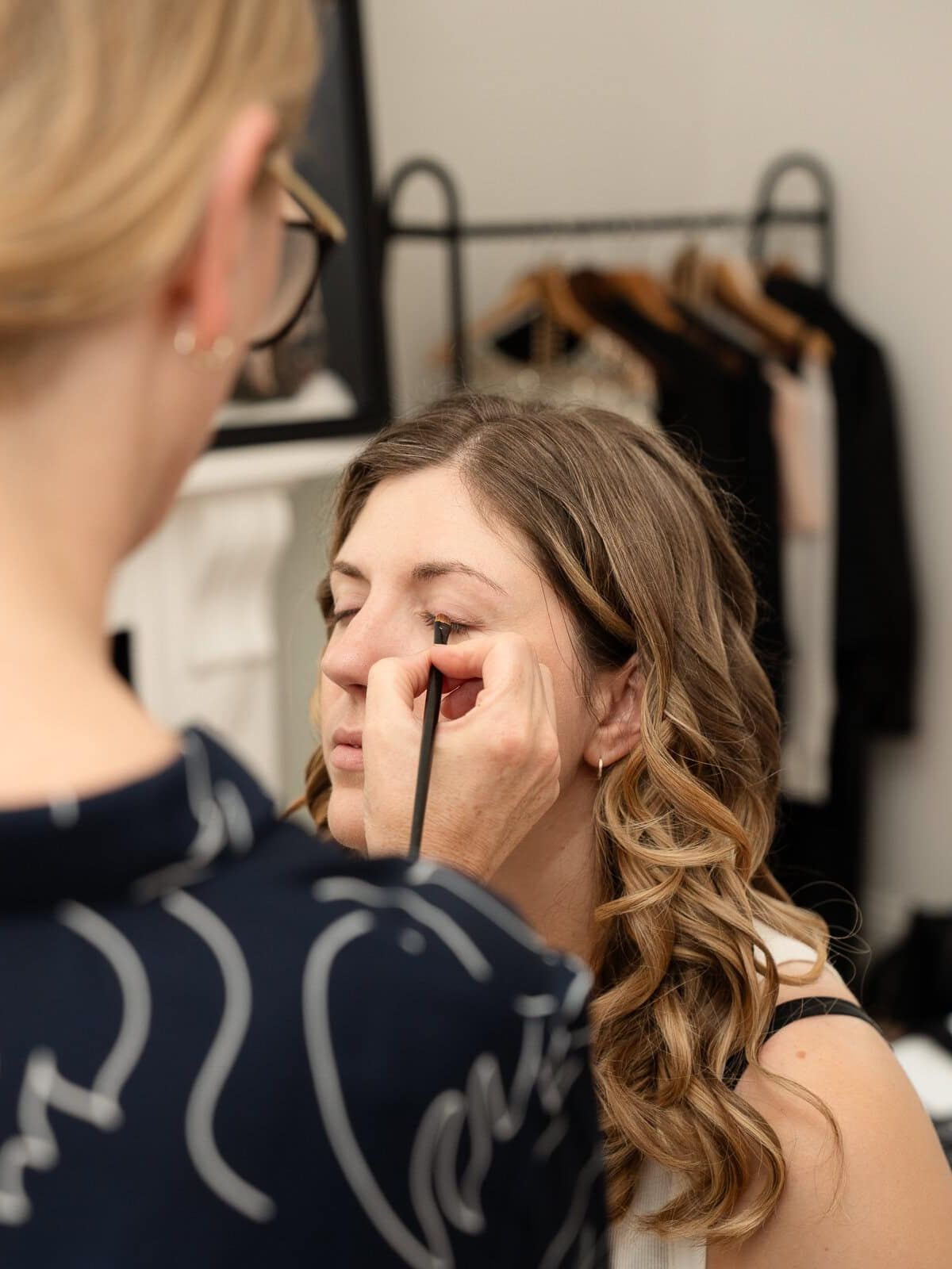a woman having makeup created by a hair and makeup artist on her london boudoir studio session