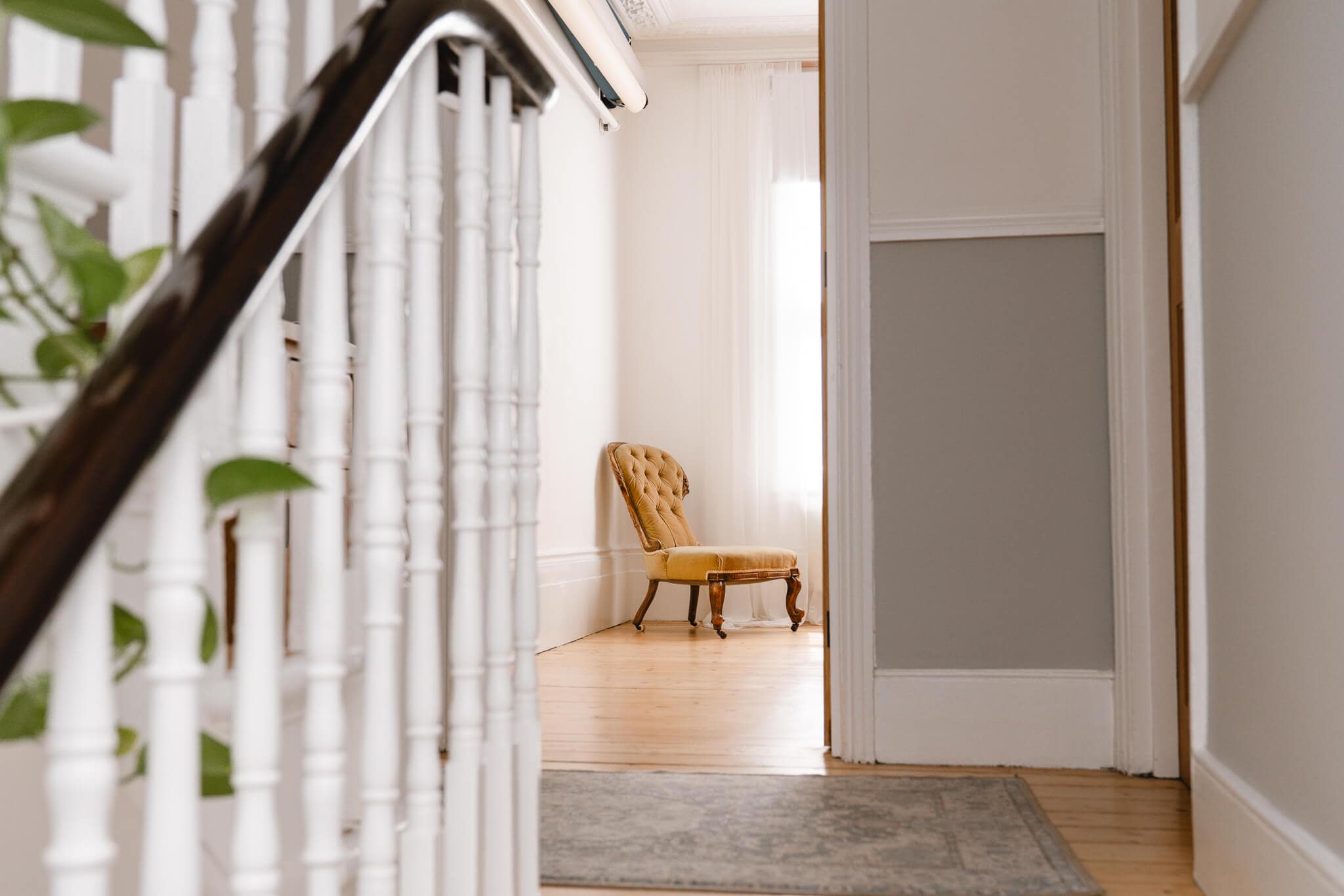 Quiet entrance to a private London boudoir studio with wooden floors and a softly lit room beyond.