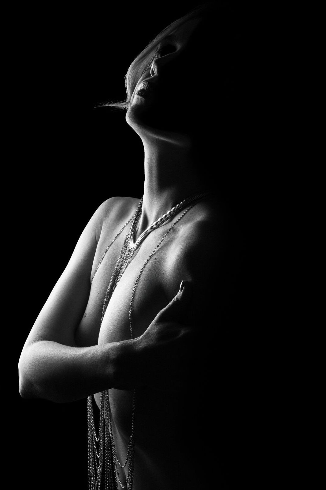 a woman in a body chain on a Dark and sultry boudoir photograph in London.