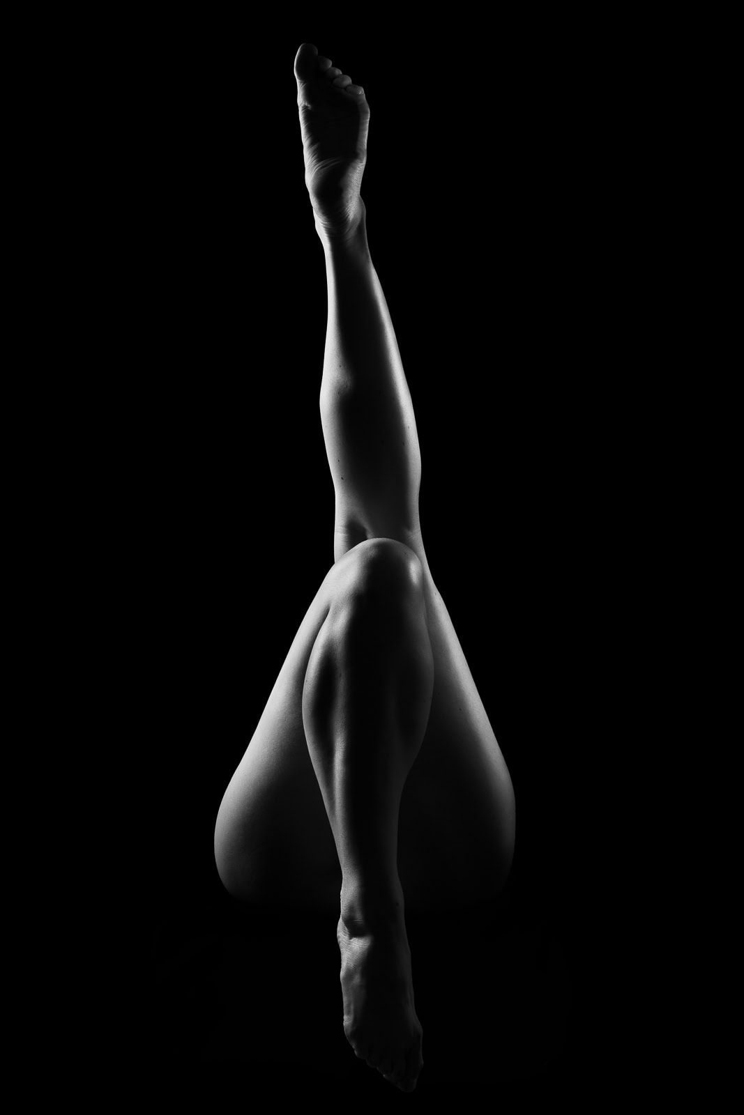 Tasteful implied nude with artistic lighting in a dark and sultry boudoir style