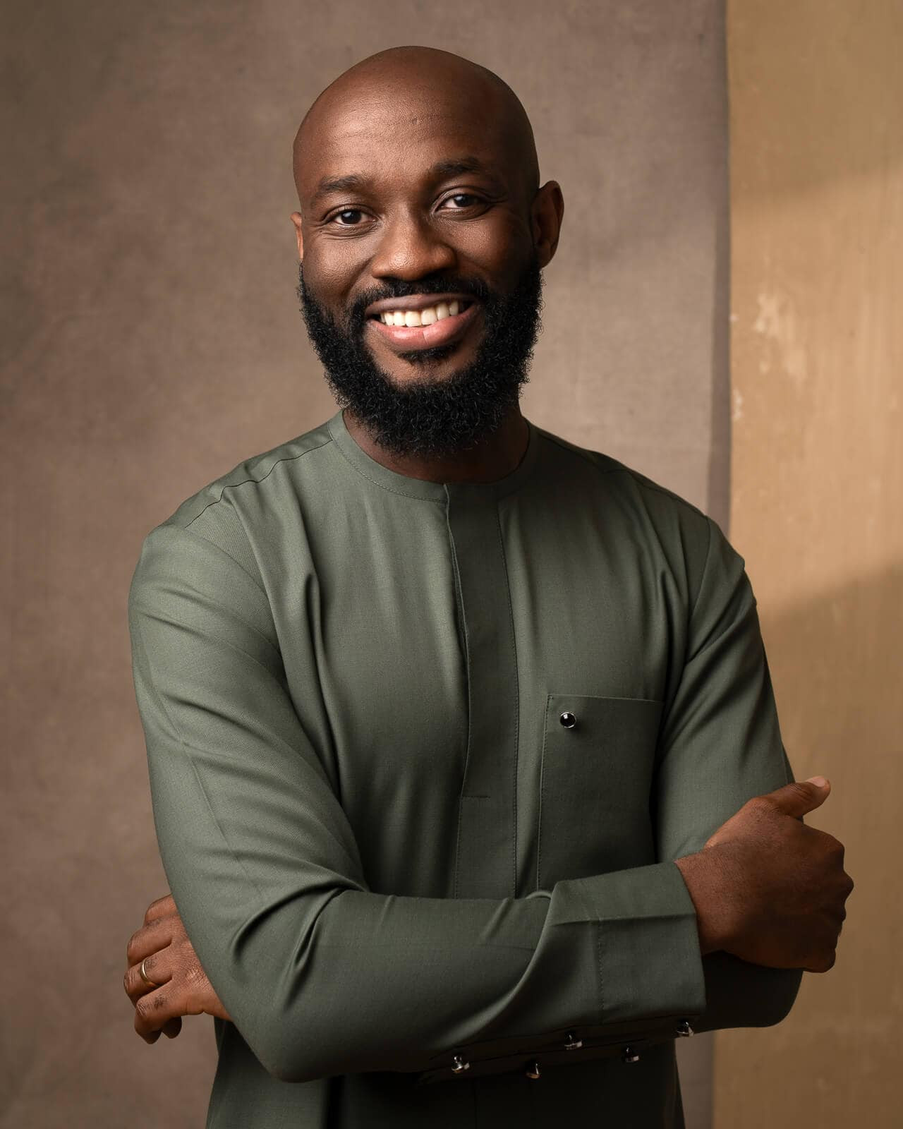 London portrait photographer captures a Black man in a green outfit with creative lighting against a yellow background