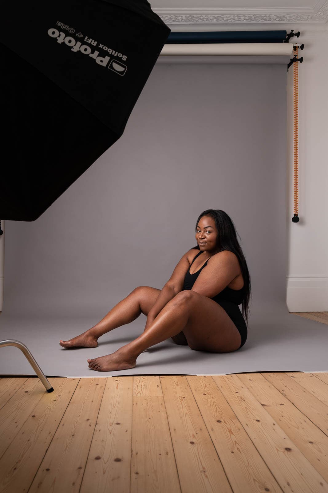 behind the scenes image of a woman from the exhibition smiling, under studio lighting