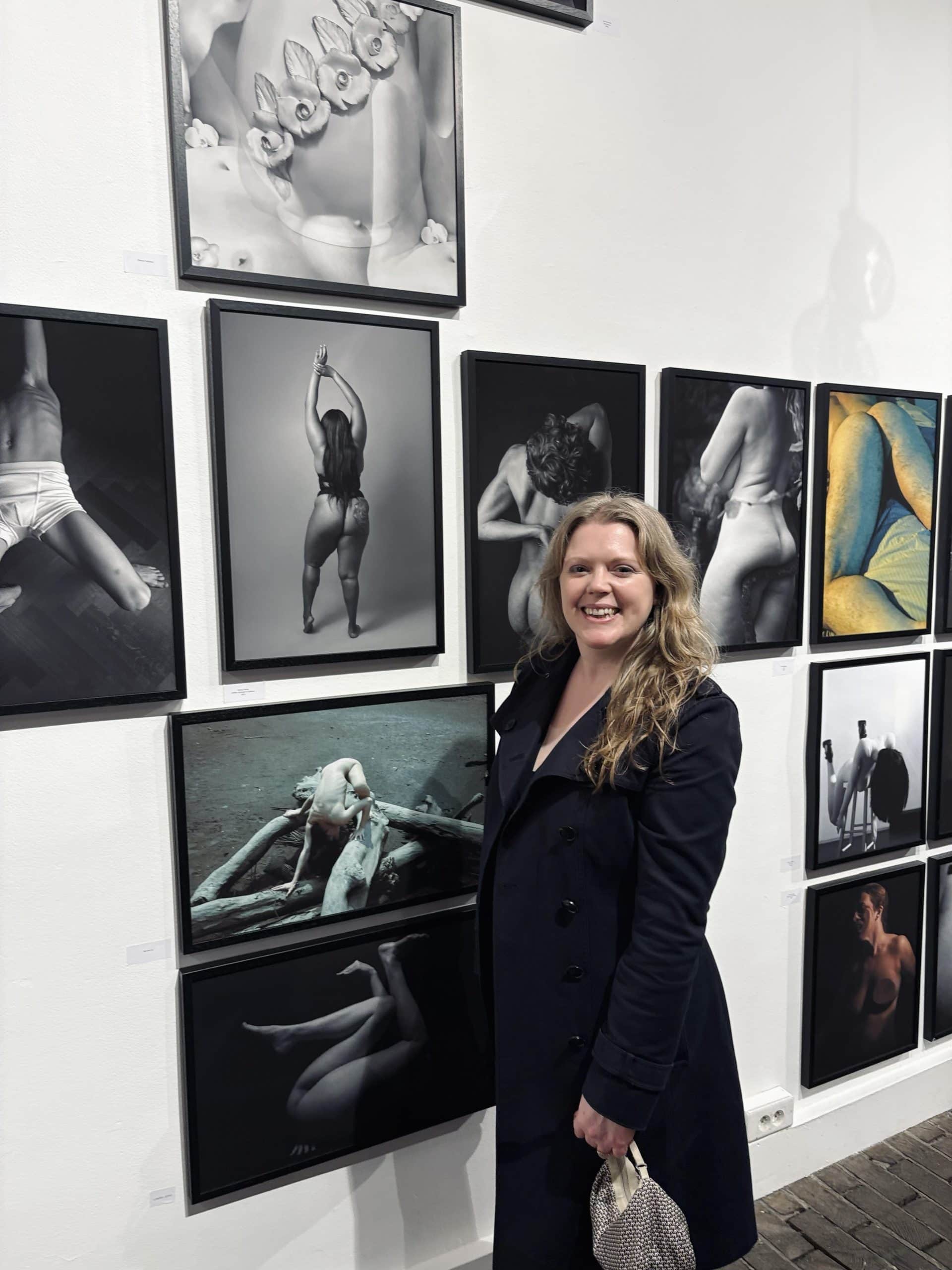 Photographer Siorna Ashby standing beside her exhibited fine art nude photograph at the Bastille Design Centre in Paris, representing her work as a London boudoir photographer recognised internationally