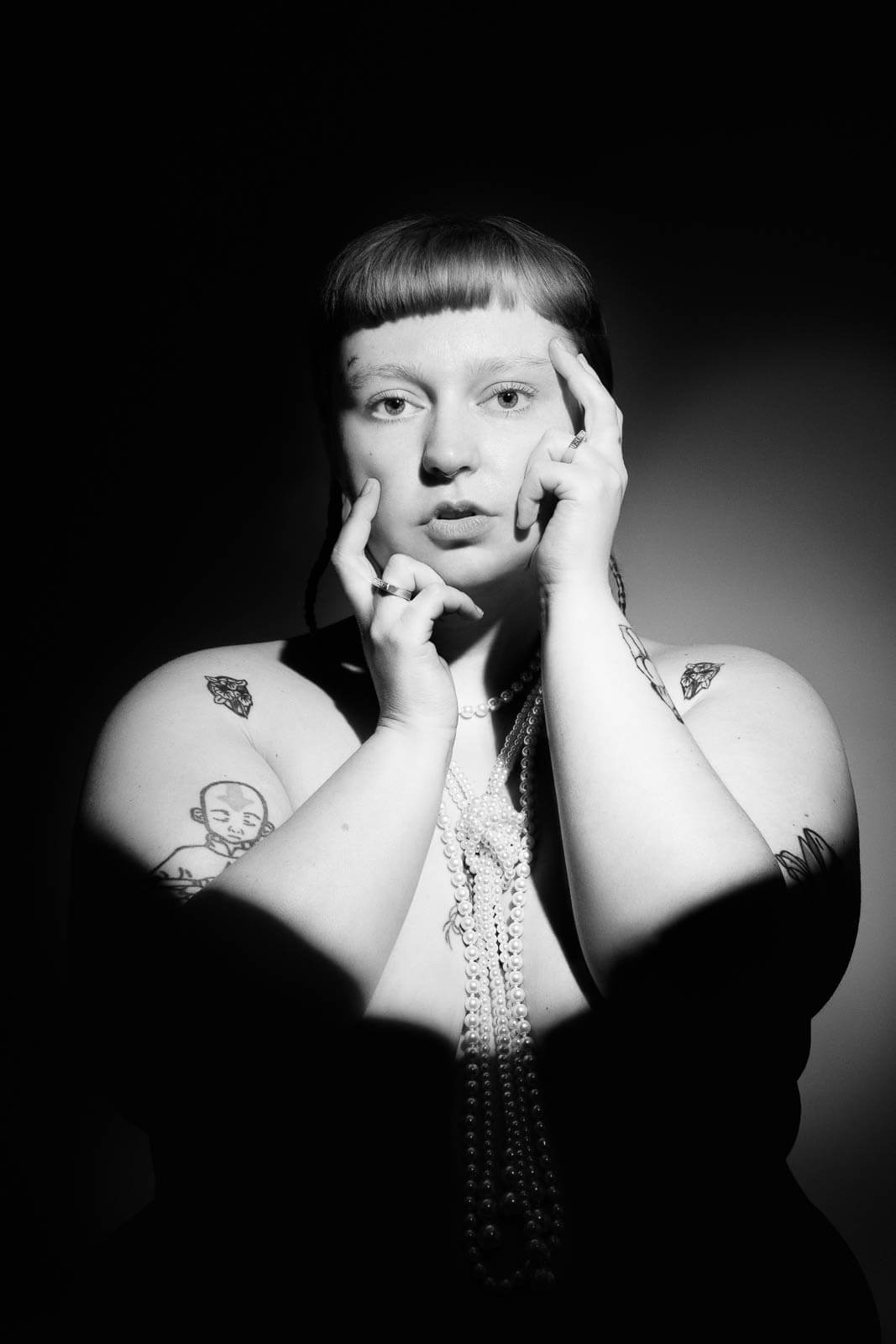Black and white portrait showing how boudoir photography styles by mood can combine confidence and shadow.