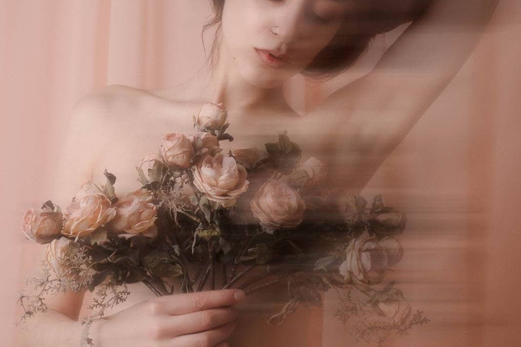 Romantic boudoir portrait with pink drapery and roses for boudoir photography styles by mood.