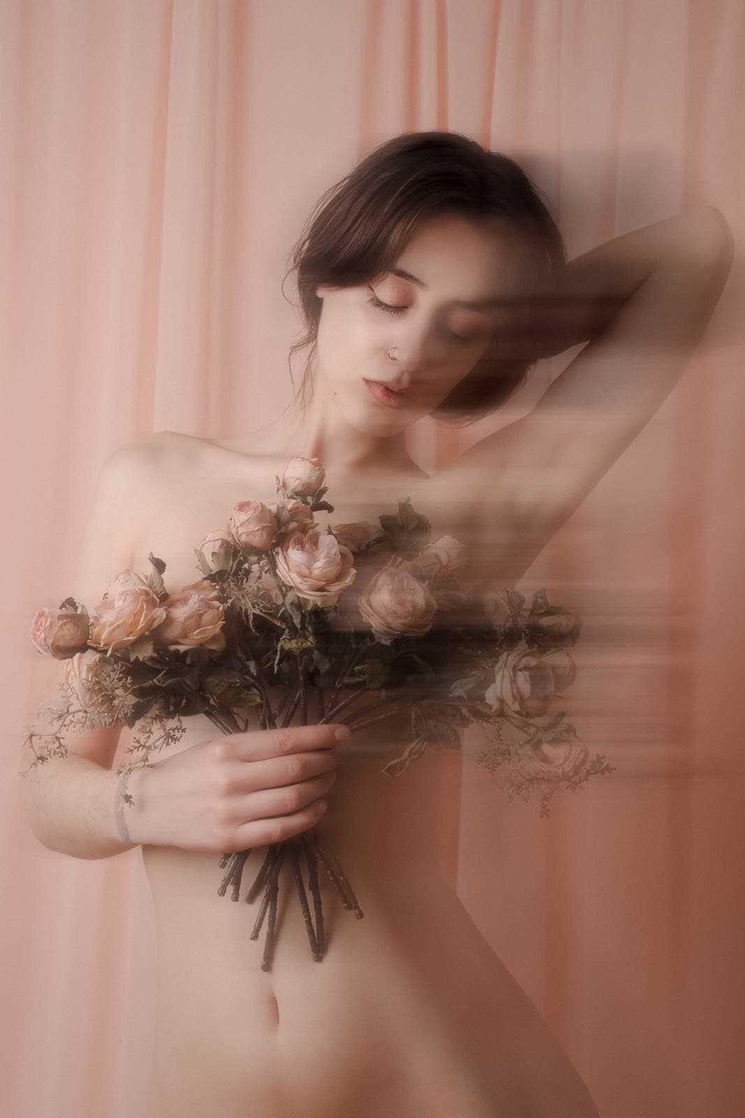 Romantic London boudoir photography portrait with pink drapery and roses.