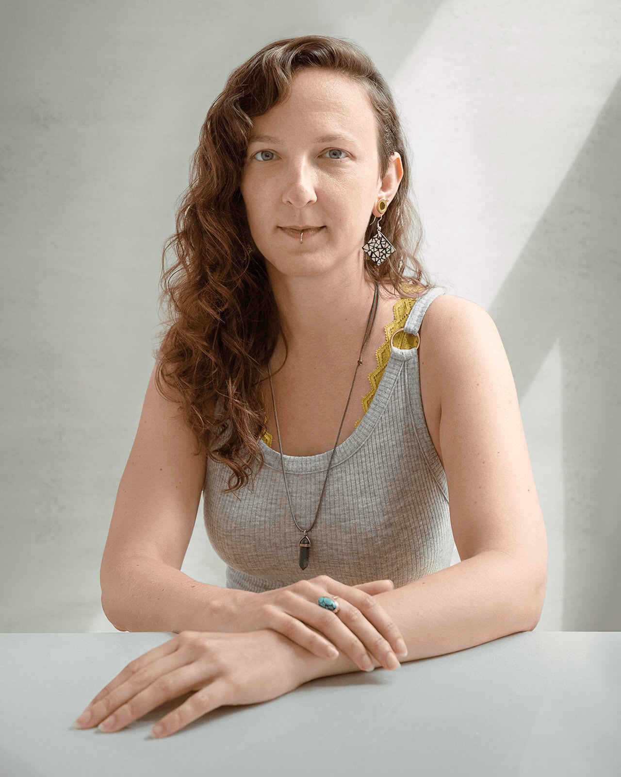Creative professional headshot of a woman seated at a desk in a London photography studio.