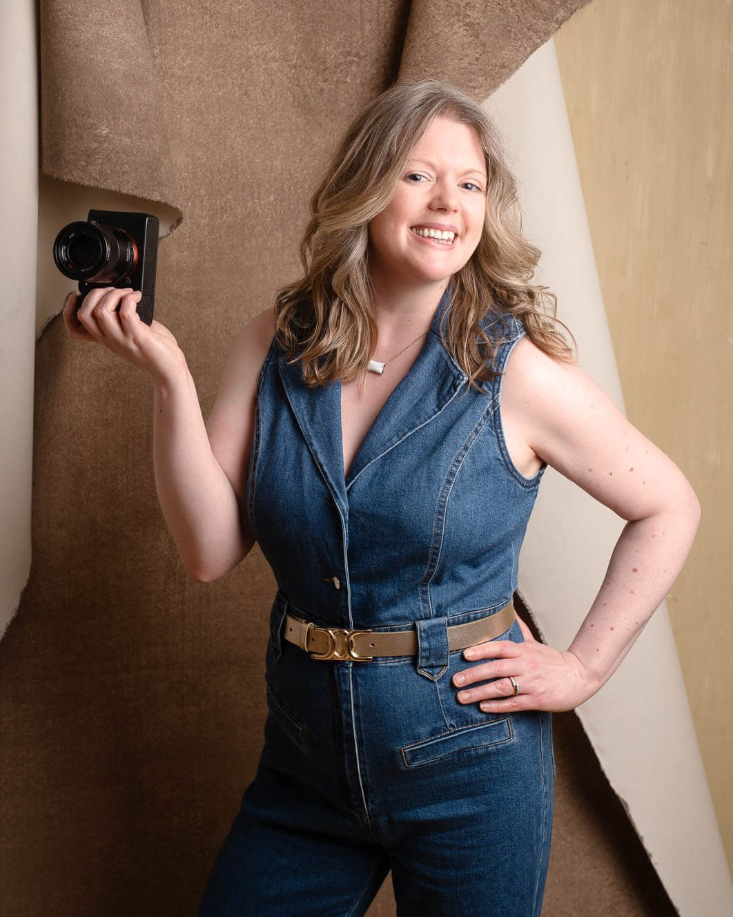 London portrait photographer Siorna Ashby smiling in her studio while holding a camera