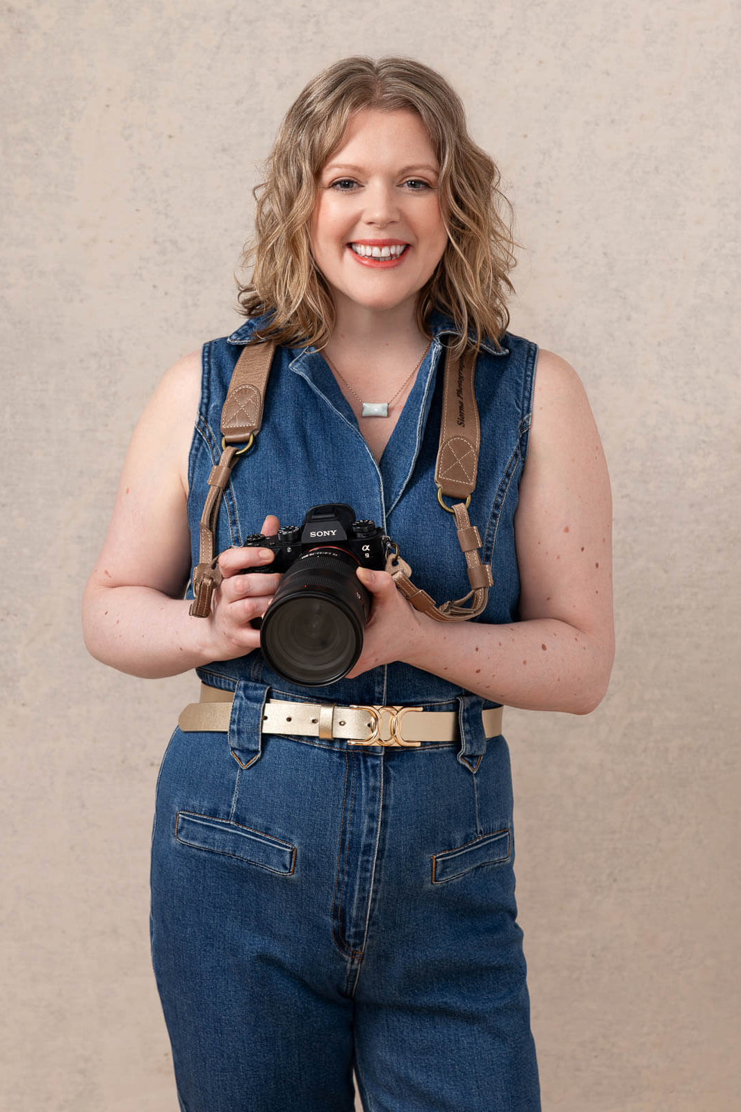 London headshot photographer Siorna smiling with her camera in the studio.