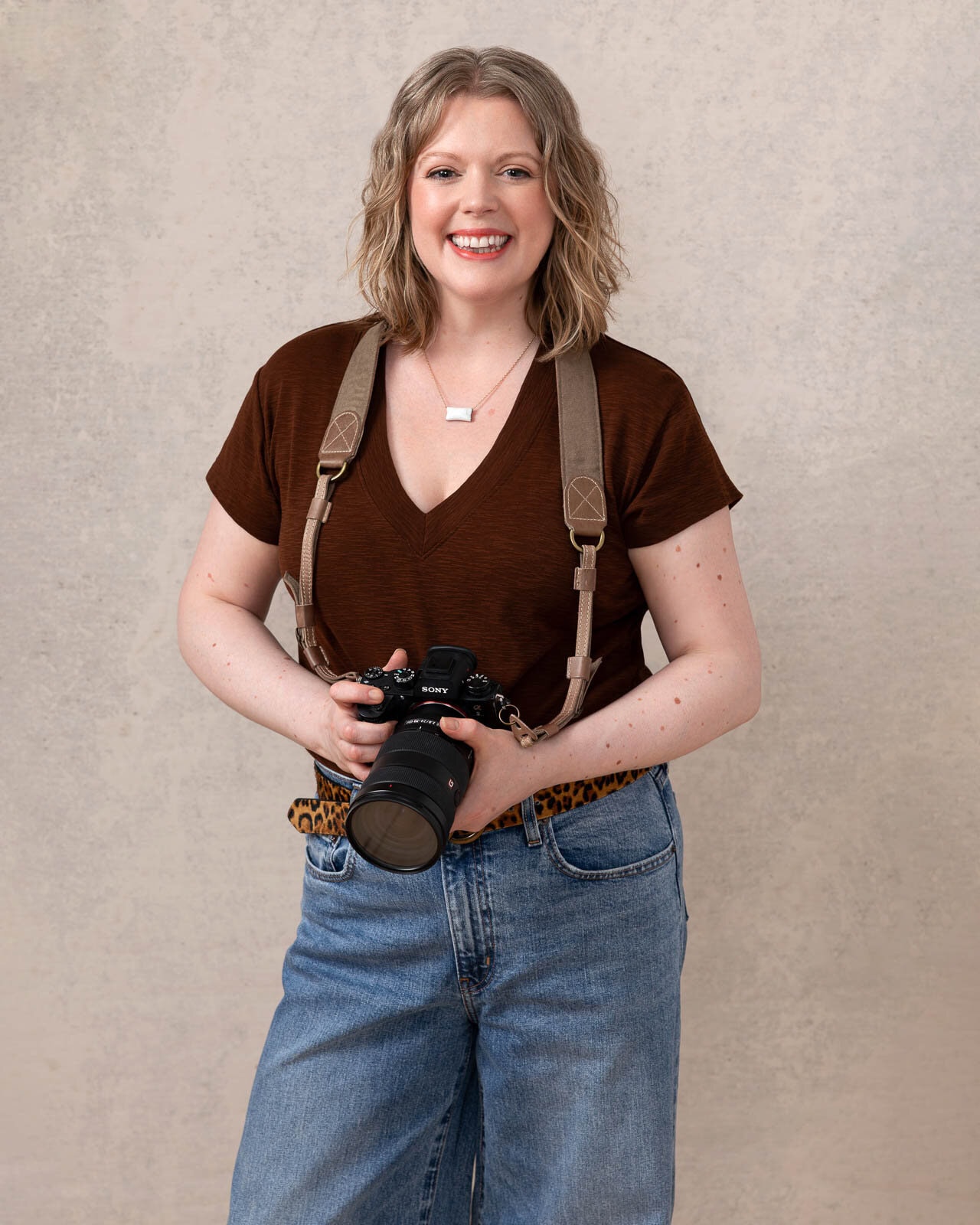 Siorna, a London boudoir photographer, smiling with her camera.